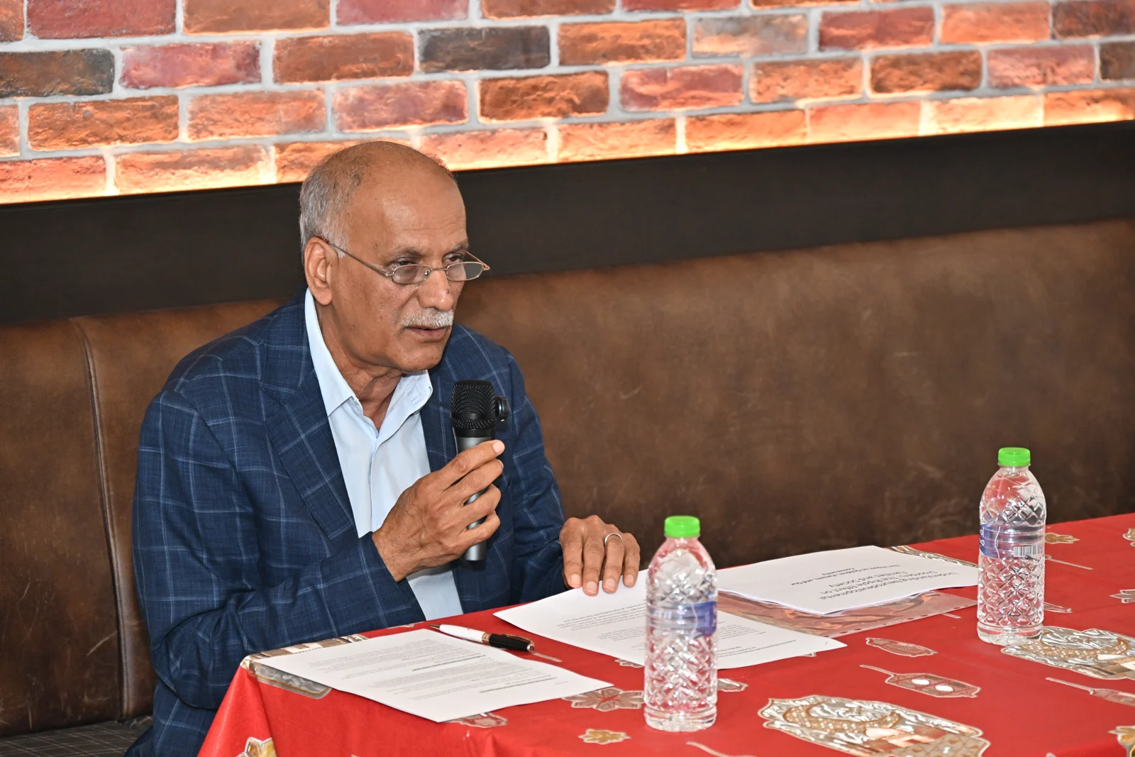 Professor Ahmed Malallah Al-Ansari speaking into a microphone at a table