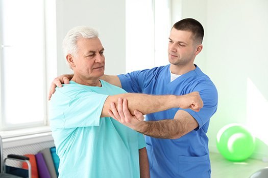 A rehabilitation professional supporting an older adult