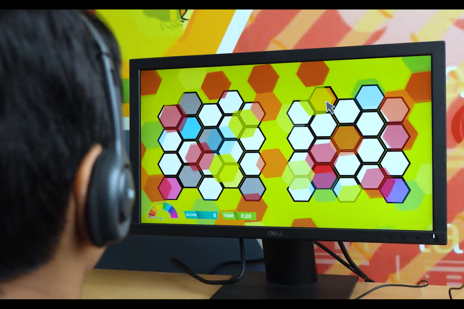 A person using headphones while completing a colourful ReadON cognitive activity on a computer